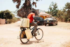 A rider carrying jerrycans of water on a Karaa electric bike
