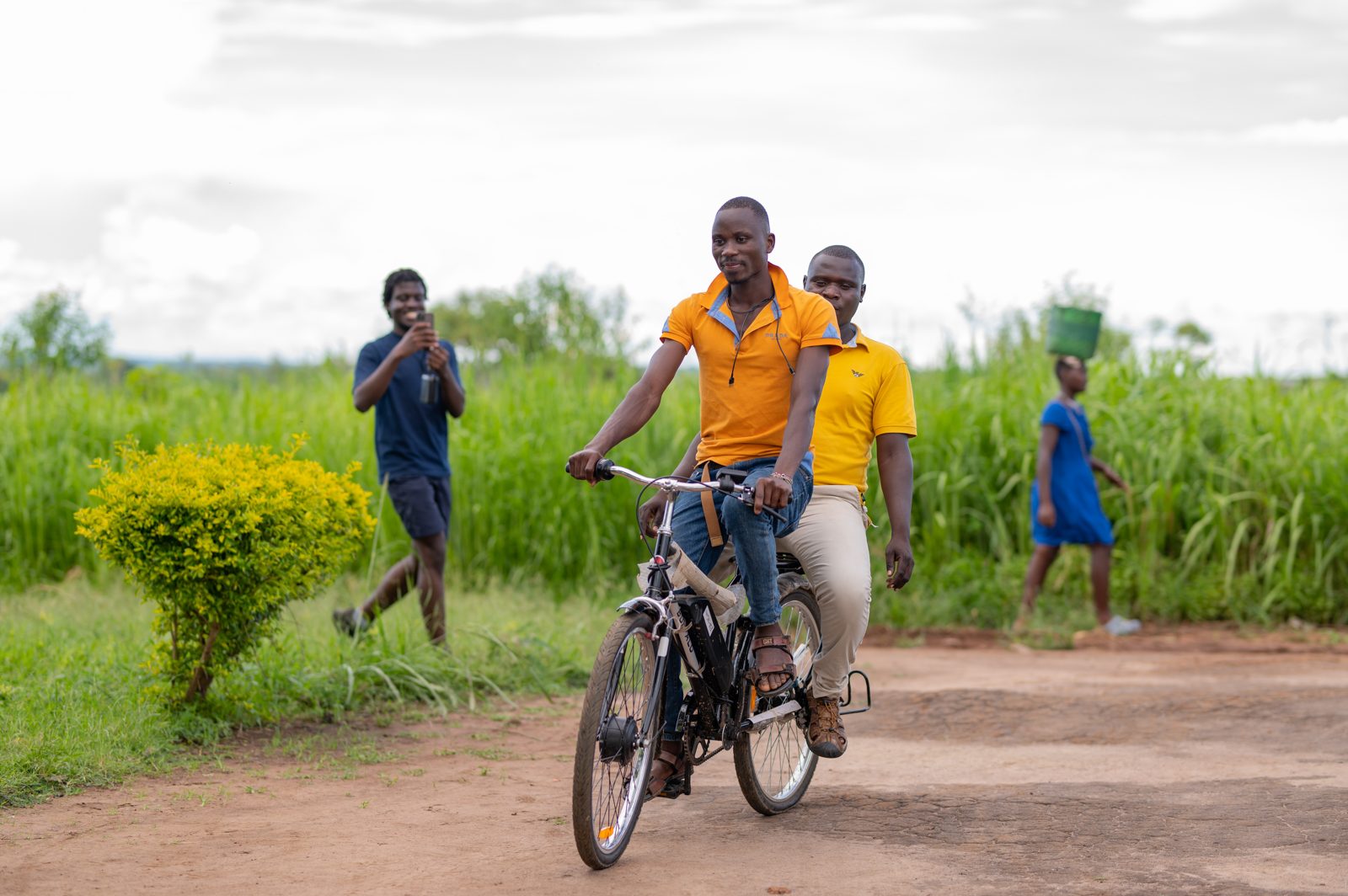 Two men riding a Karaa electric bike on a rural road